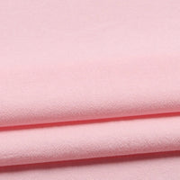 A close-up of folded Longan Craft Solid Color Washed Crepe Fabric by the yard, made from 100% cotton crepe in light pink, highlighting its soft and textured finish—ideal for pants and clothing material.