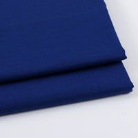Two neatly folded pieces of Longan Craft Solid Color Wool Gabardine Fabric, a rayon polyester blended twill ideal for casual wear, are stacked on a white surface.