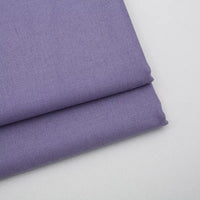 Two neatly folded pieces of Longan Craft Solid Color Wool Gabardine Fabric are stacked on a white surface, featuring a smooth and slightly textured rayon-polyester blended twill ideal for casual wear.