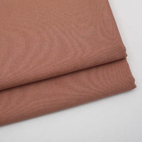 Two neatly folded pieces of Longan Craft's Solid Color Wool Gabardine Fabric, a rayon-polyester blended twill, are stacked on a white surface—smooth and soft, ideal for casual wear and tailoring projects.