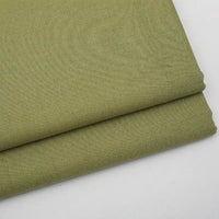 Two neatly folded pieces of Longan Craft's Solid Color Wool Gabardine Fabric By The Yard, a rayon-polyester blended twill ideal for casual wear, are stacked on a white surface, highlighting the fabric’s smooth and slightly textured weave.