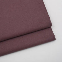 Two neatly folded pieces of Longan Craft Solid Color Wool Gabardine Fabric By The Yard lie on a white surface, showcasing the smooth, clean-edged rayon polyester blended twill material—ideal for creating stylish casual wear.