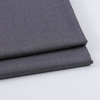 Two neatly folded pieces of Longan Craft Solid Color Wool Gabardine Fabric By The Yard, a rayon polyester blended twill ideal for casual wear, are stacked on a white surface, displaying a subtle weave texture in dark gray.
