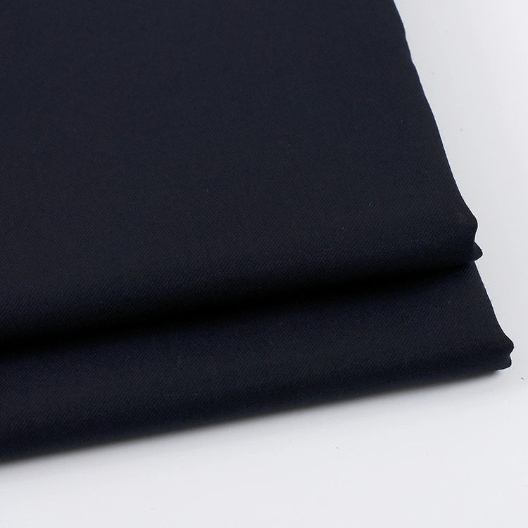 A close-up of two neatly folded layers of Longan Craft’s Solid Color Wool Gabardine Fabric, a rayon-polyester blend twill ideal for casual wear, displayed on a white surface.