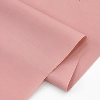 A close-up of two overlapping sheets of Longan Craft Solid Cotton Lawn Fabric by the yard, a cozy cotton-polyester lawn cloth material, displayed on a flat surface.