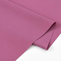 A close-up of two overlapping mauve Solid Cotton Lawn Fabrics by Longan Craft, neatly arranged on a white surface. This polyester lawn cloth is ideal for cozy dressmaking and is sold by the yard.