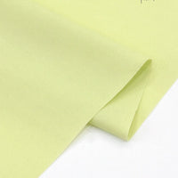 A close-up of Longan Craft’s Solid Cotton Lawn Fabric by the yard, a soft, light yellow polyester lawn cloth for cozy dresses, neatly folded and shown on a white background.