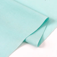 Two overlapping pieces of Longan Craft Solid Cotton Lawn Fabric by the Yard (polyester lawn cloth material) in light blue are laid on a white surface, showing their smooth, slightly folded edges.