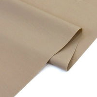 A close-up of Longan Craft’s Solid Cotton Lawn Fabric by the yard shows the smooth, light brown cotton-polyester material slightly folded, highlighting its soft texture and elegant drape—ideal for cozy lawn dress projects.