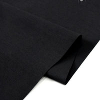 A close-up of Solid Cotton Lawn Fabric by Longan Craft, a plain black breathable polyester lawn cloth material, folded against a white background.