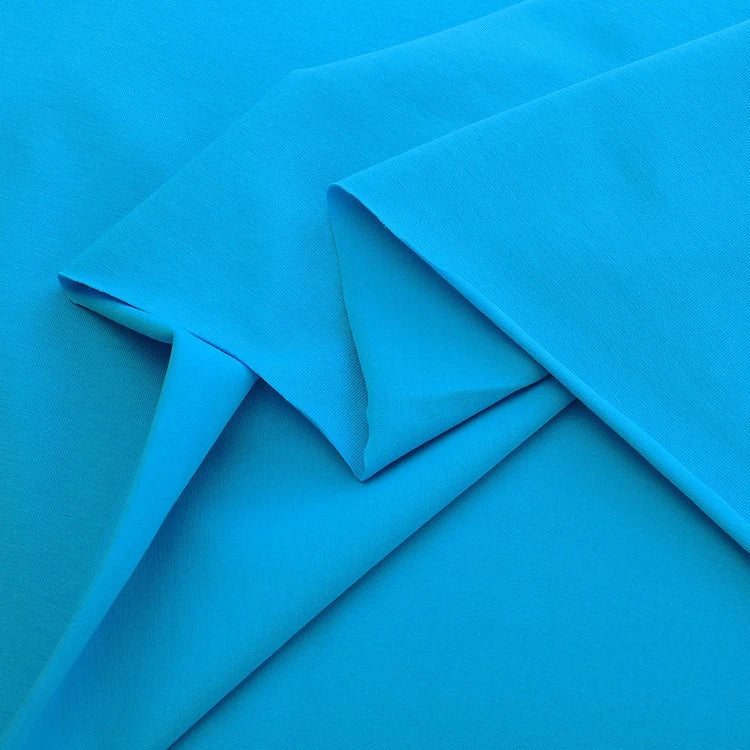 Multiple pieces of Longan Craft's Spandex Jersey Fabric By The Yard in bright blue are neatly layered, highlighting its smooth texture, clean edges, lightweight feel, and impressive four-way stretch—ideal for dressmaking.