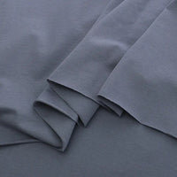 Overlapping pieces of Longan Craft's Spandex Jersey Fabric By The Yard in dark grey display its soft texture, clean edges, and subtle four-way stretch—ideal as a solid color cotton jersey stretch dress fabric.