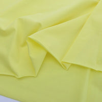 A close-up of Longan Craft's Spandex Jersey Fabric By The Yard highlights its soft, smooth yellow cotton jersey texture, lightweight feel, and subtle four-way stretch—ideal for dressmaking and crafts.