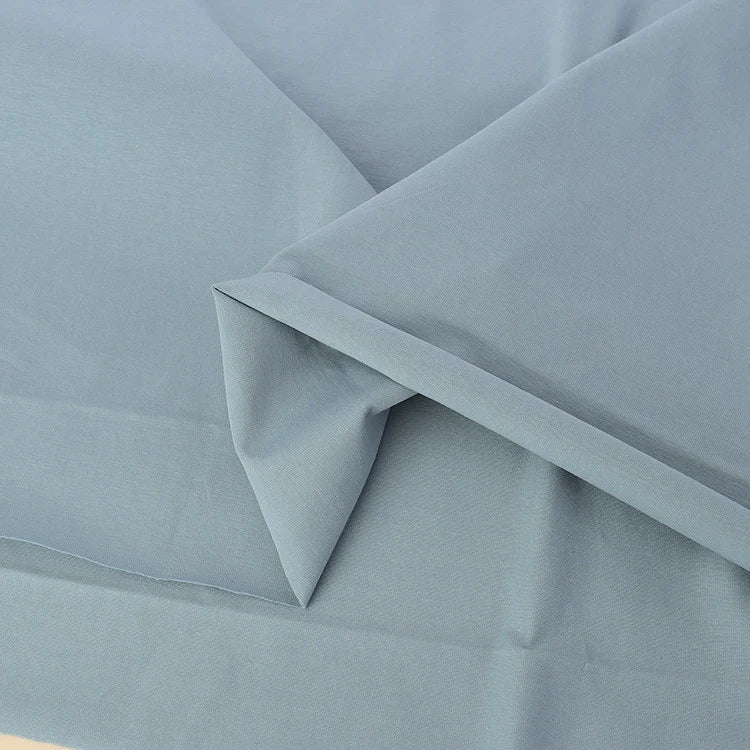 A close-up of Longan Craft's Spandex Jersey Fabric By The Yard in light blue shows its soft texture, neat edges, and impressive four-way stretch—the ideal solid color cotton jersey fabric for stretch jersey dress projects.