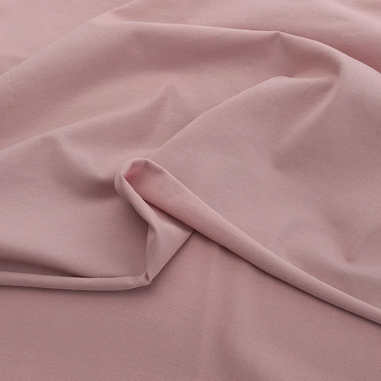 A close-up of Longan Craft’s Solid Color Cotton Spandex Jersey Fabric By The Yard, draped in gentle folds to highlight its soft, matte texture and subtle four-way stretch—ideal as a stretch jersey dress fabric.