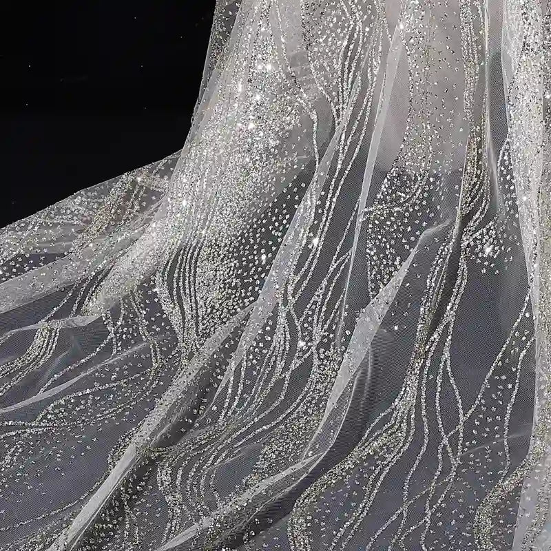 Close-up of Longan Craft’s Sparkle Glitter Tulle Fabric By The Yard, a multicolor shiny tulle material with beads and sequins, perfect for evening gowns. Wave-like patterns shimmer elegantly against a dark background.