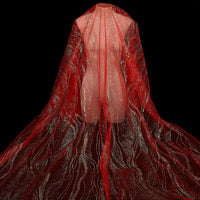 A faceless mannequin is draped in Longan Craft's Sparkle Glitter Tulle Fabric By The Yard, featuring swirling multicolor shine. The delicate tulle for evening gowns flows dramatically over the figure against a solid black background.