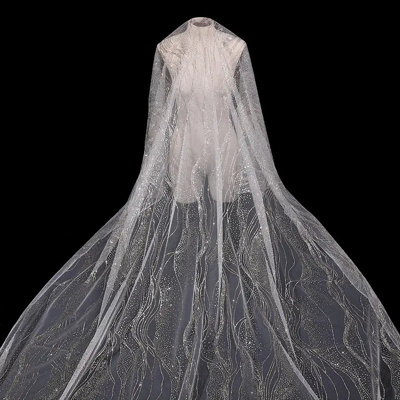 A sheer evening gown cape made from Longan Craft’s Sparkle Glitter Tulle Fabric by the Yard features multicolor shine and delicate patterns, flowing elegantly against a black background.