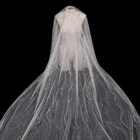 A sheer evening gown cape made from Longan Craft’s Sparkle Glitter Tulle Fabric by the Yard features multicolor shine and delicate patterns, flowing elegantly against a black background.