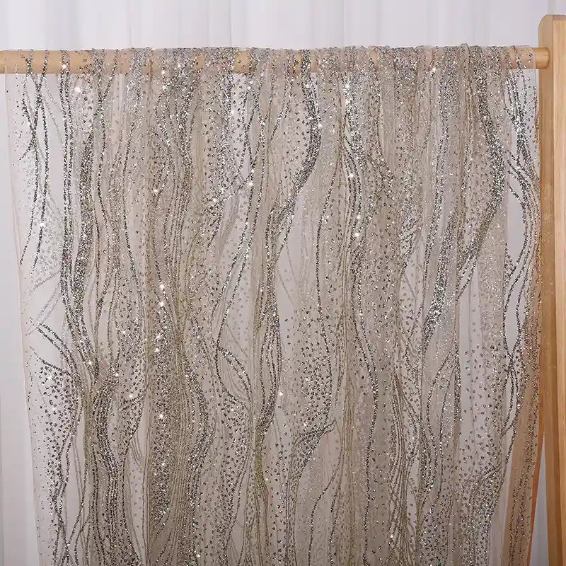 A panel of Sparkle Glitter Tulle Fabric By The Yard from Longan Craft hangs on a wooden rod, featuring multicolor shimmer and delicate patterns that add a touch of elegance perfect for evening gowns.