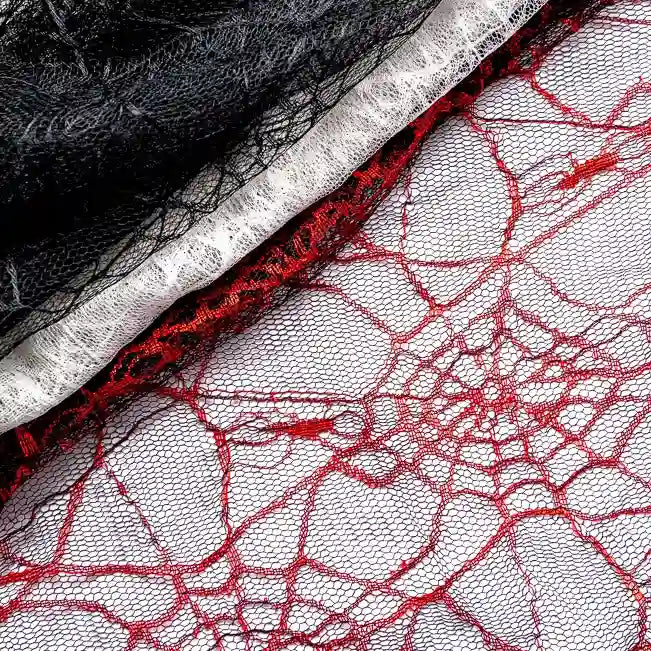 Rolls of lace fabric, including Longan Craft’s Spider Web Tulle Fabric By The Yard—a colorful Halloween tulle perfect for DIY party dresses—are stacked in black, white, and red, showcasing fine mesh detail and festive textures.