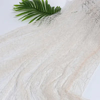 Longan Craft’s Spider Web Tulle Fabric By The Yard—colorful Halloween tulle perfect for DIY party dresses—is displayed flat with a green palm leaf in the corner, ideal for festive décor or creative costumes.