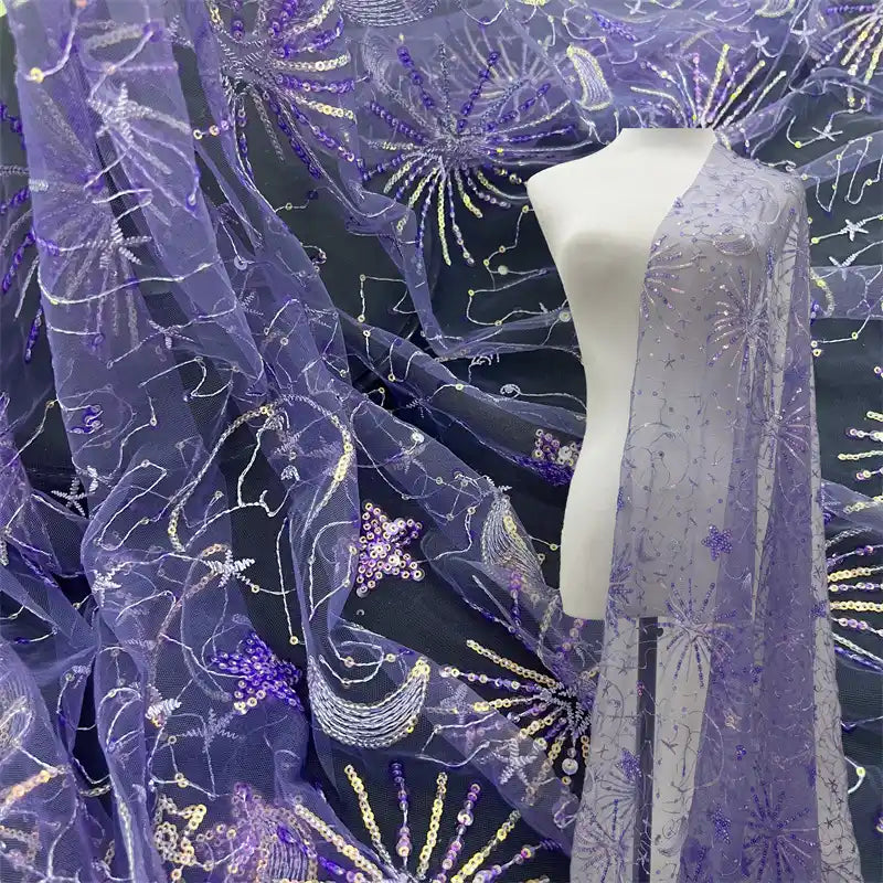 Longan Craft's Star and Moon Sequin Embroidered Tulle Fabric By The Yard is draped over a mannequin, with more sparkling tulle material elegantly laid out in the background—perfect for creating DIY dresses.