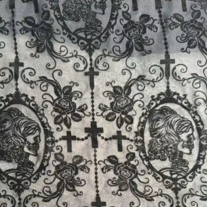 The Stretch Floral Spandex Tulle Fabric by Longan Craft features richly patterned black flocked tulle with gothic-style skeleton cameos, ornate roses, vines, and crosses—perfect for unique dancewear or dressmaking projects.