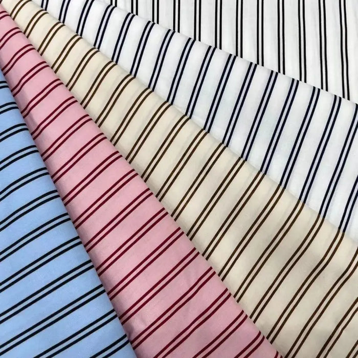 Five folded Striped Cotton Lawn Fabrics by Longan Craft in white, beige, pink, blue, and off-white are arranged side by side. Made from breathable cotton lawn, these fabrics are ideal for summer dressmaking and apparel projects.