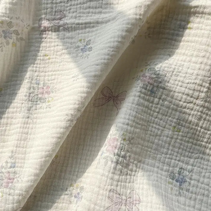 A softly sunlit close-up of Longan Craft’s Striped Floral Print Gauze Fabric by the yard, made from 100% cotton double gauze and adorned with a delicate striped floral pattern—an ideal choice for crafting pajamas.