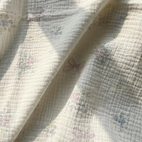 A softly sunlit close-up of Longan Craft’s Striped Floral Print Gauze Fabric by the yard, made from 100% cotton double gauze and adorned with a delicate striped floral pattern—an ideal choice for crafting pajamas.