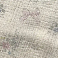 Experience the delicate charm of Longan Craft’s Striped Floral Print Gauze Fabric by the yard—a pale, quilted 100% cotton double gauze material featuring faint pink bows and subtle floral patterns lightly scattered across its surface, perfect for pajamas and cozy projects.