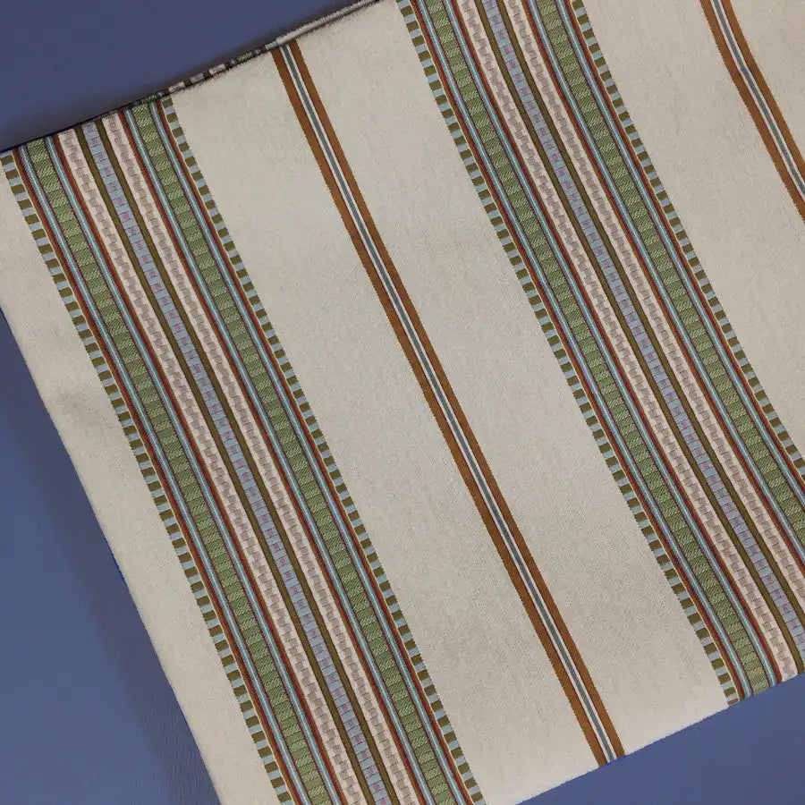 Longan Craft’s Striped Jacquard Chenille Fabric By The Yard showcases vertical brown, green, and purple stripes on a cream and blue background. This high-quality 100% poly chenille upholstery fabric adds decorative texture to cushions or furniture.