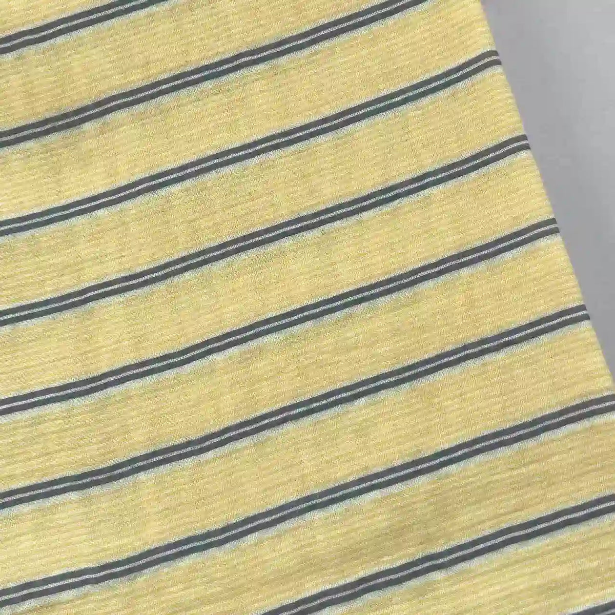 Longan Craft’s Striped Printed Gauze Fabric by the yard features yellow, gray, and white stripes. Made from double 100% cotton gauze, this breathable material is cozy with a slightly ribbed texture and shown photographed at an angle.