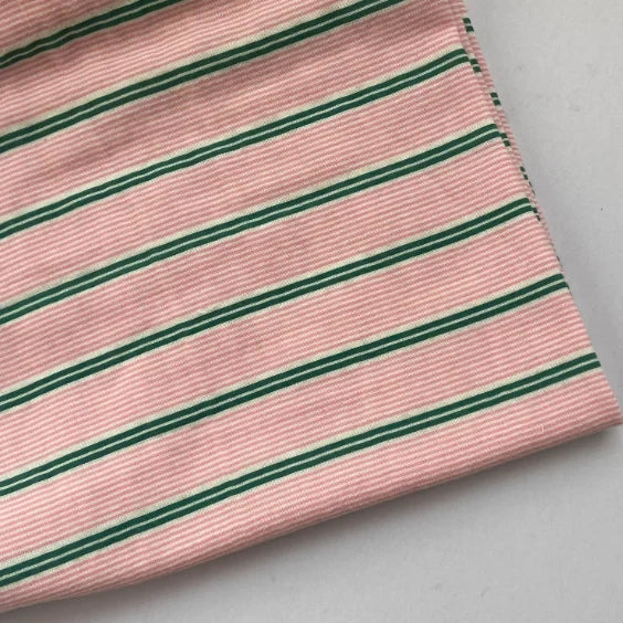 A piece of Longan Craft Striped Printed Gauze Fabric By The Yard, made from double 100% cotton with a pink background and evenly spaced horizontal green and white stripes, shown on a light gray surface.