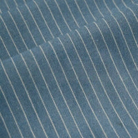 Close-up of Longan Craft’s Striped Printed Linen Fabric By The Yard, a cotton linen blend with colorful stripe pattern, highlighting the breathable fabric’s texture and a diagonal fold in the material.