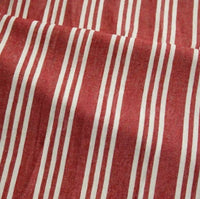 The Striped Printed Linen Fabric By The Yard from Longan Craft is a breathable cotton linen blend fabric featuring a colorful stripe pattern with evenly spaced vertical white stripes of varying widths on a red background. This slightly textured fabric may appear softly wrinkled or folded, making it ideal for dresses and other garment projects.