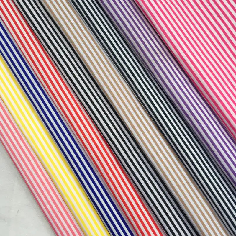 The Longan Craft Striped Printed Peachskin Fabric By The Yard features a wrinkle-resistant polyester peachskin material with vibrant diagonal stripes in pink, purple, black, brown, red, yellow, and blue—perfect for DIY clothing projects.