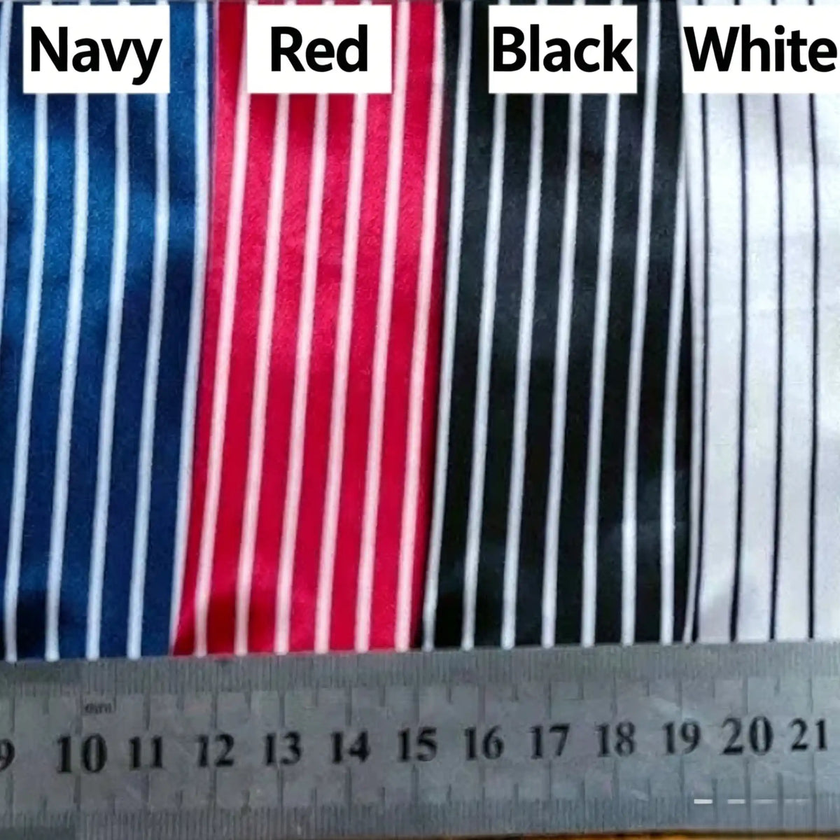 Four pieces of Longan Craft Striped Printed Satin Fabric By The Yard in navy, red, black, and white display crisp white vertical stripes. A ruler shows scale for this premium dressmaking satin material with a shiny stripe pattern.