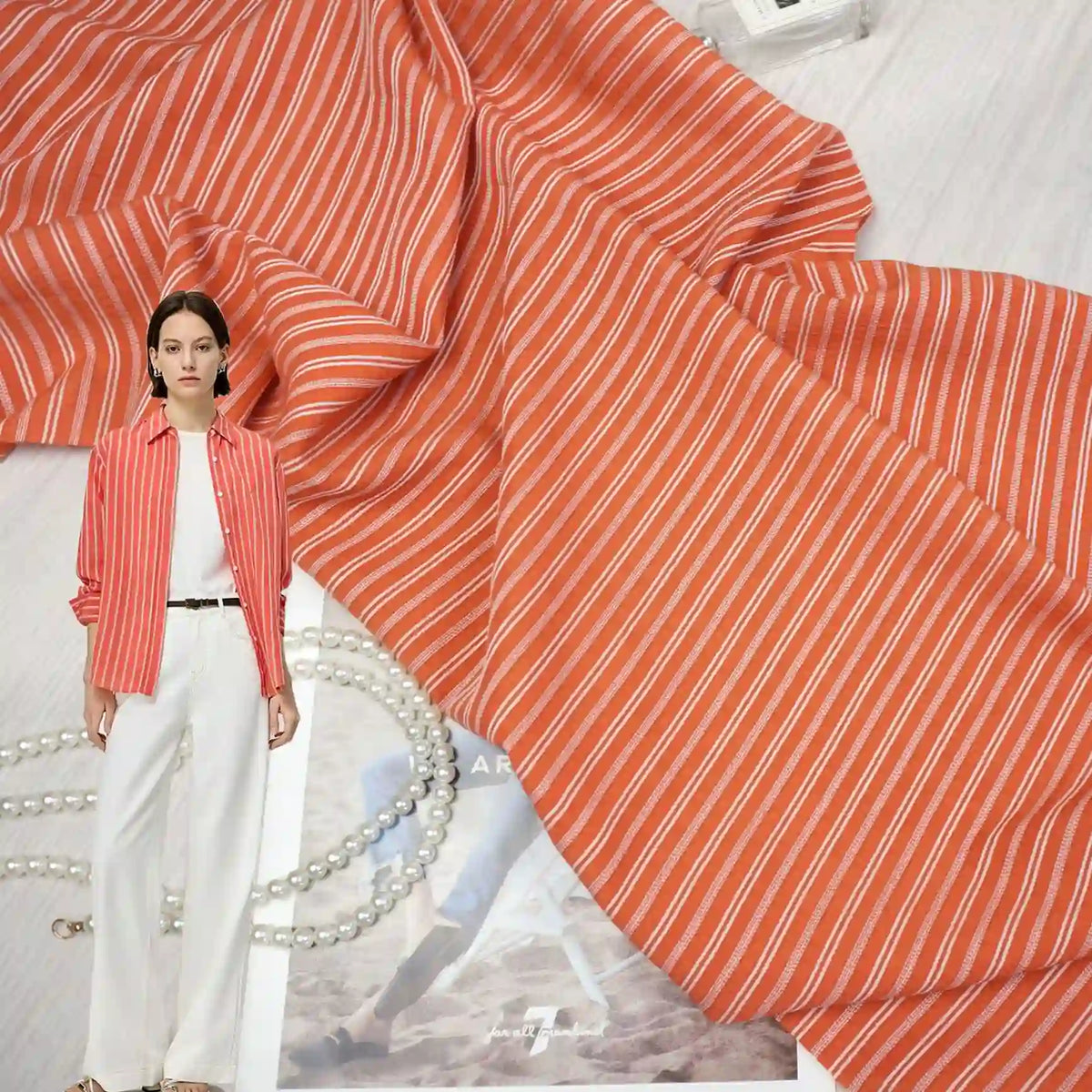 Striped Rayon Dobby Fabric By The Yard from Longan Craft is shown, featuring red and white vertical stripes. A model in a matching blouse and white pants appears on the left, while accessories highlight the jacquard dobby texture.
