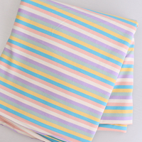 Longan Craft Striped Jersey Fabric by the Yard features comfy cotton spandex with diagonal pastel stripes on white, ideal for DIY short sleeves. Displayed folded on a light surface.