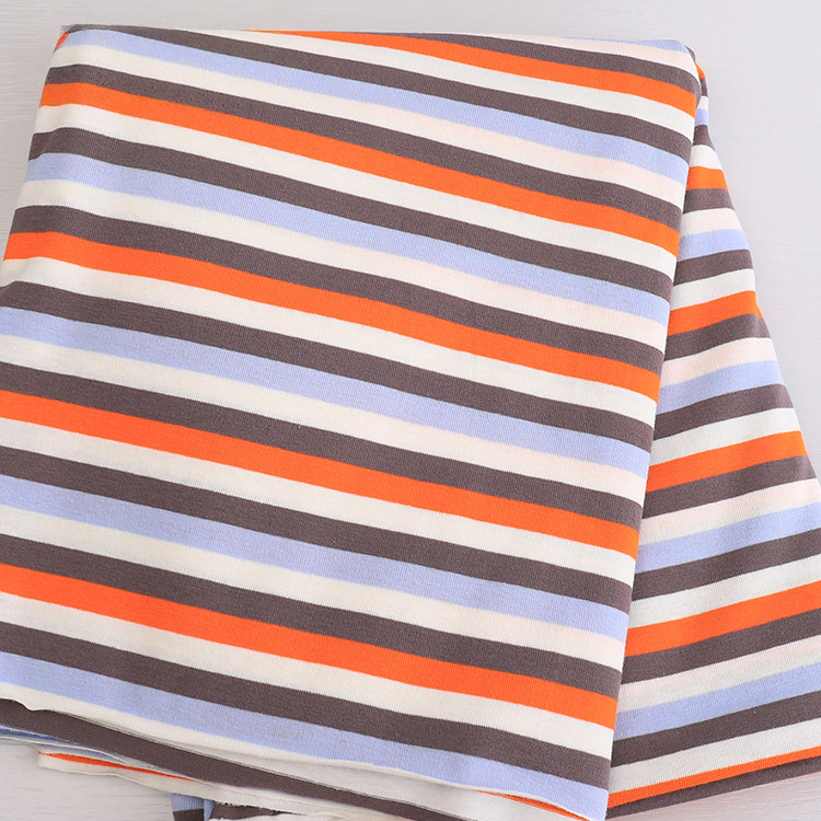 Longan Craft's Striped Jersey Fabric By The Yard features diagonal orange, brown, light blue, and white stripes in a repeating pattern. This comfy stretchable cotton spandex textile is perfect for DIY short sleeves and is shown on a light surface.