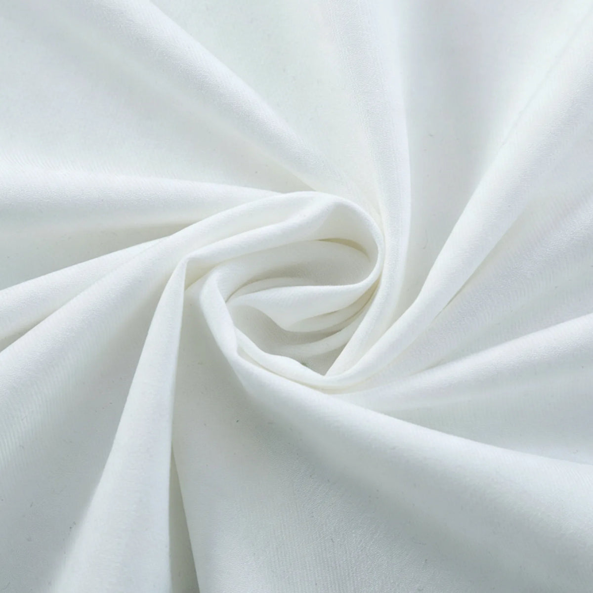 A close-up of Longan Craft Thick Cotton Gabardine Fabric by the yard, twisted to highlight its plain twill weave, smooth texture, and soft, sturdy folds—perfect for uniforms and more.