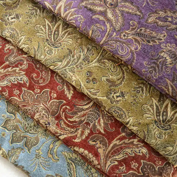 Four rolls of Longan Craft’s Thick Viscose Chenille Fabric By The Yard in purple, green, red, and blue with gold and beige botanical jacquard patterns are stacked diagonally. Ideal for durable draperies and luxurious upholstery projects.