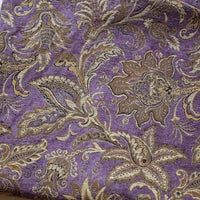 A close-up of Longan Craft's Thick Viscose Chenille Fabric By The Yard shows intricate gold and beige botanical patterns on a purple background—this durable Jacquard chenille is ideal for elegant sofa upholstery or draperies.