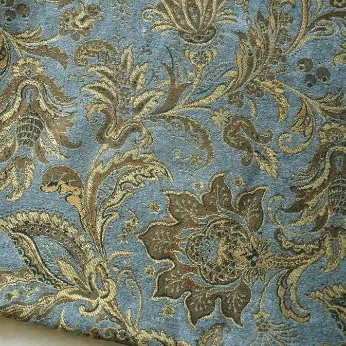 Longan Craft's Thick Viscose Chenille Fabric By The Yard features a botanical jacquard design in gold and bronze on muted blue, offering durable, elegant material—ideal for upholstery or draperies.