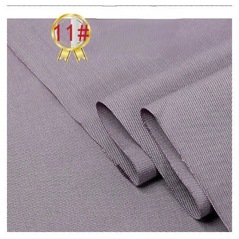 Close-up of folded Longan Craft Twill Cotton Lyocell Fabric By The Yard, a comfy and breathable solid color textile for shirts with a subtle diagonal weave. A gold ribbon badge marked 11# highlights this eco-friendly material in the upper left corner.