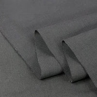 A close-up of Twill Cotton Lyocell Fabric by Longan Craft shows the solid dark grey, comfy, and breathable material—ideal for shirts. This eco-friendly Cotton Lyocell textile is smooth, slightly textured, and durable for versatile use.