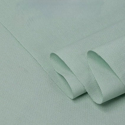 A close-up of Longan Craft’s Twill Cotton Lyocell Fabric by the yard in light green, showing its smooth, slightly textured surface and a neatly folded edge—comfy, breathable material ideal for shirts.