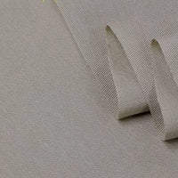 A close-up of Longan Craft’s Twill Cotton Lyocell Fabric By The Yard in light grey shows its textured, eco-friendly weave and thickness—ideal as a comfy, breathable material for shirts.